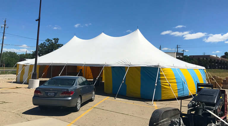 White top 30' x 60' rope and pole (one piece) tent for Kaboomers fireworks Des Moines, Iowa with blue and yellow side walls