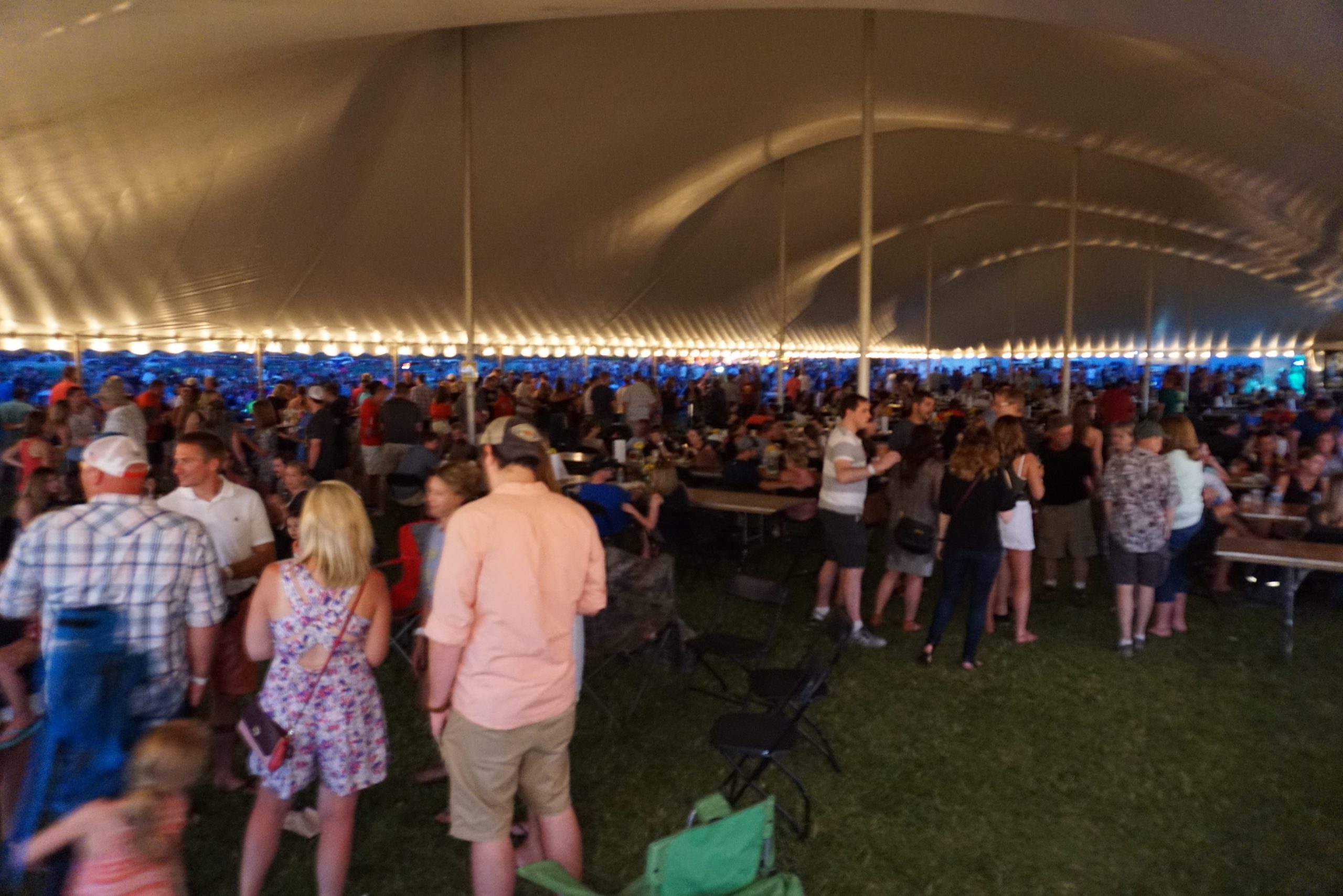 People under the 60′ x 150′ “twin pole” Legend rope and pole tent at Blues and BBQ in North Libery, Iowa