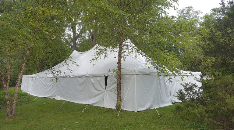 Backyard Wedding Reception Tent, with white walls, surrounded by Trees in Monticello, IA