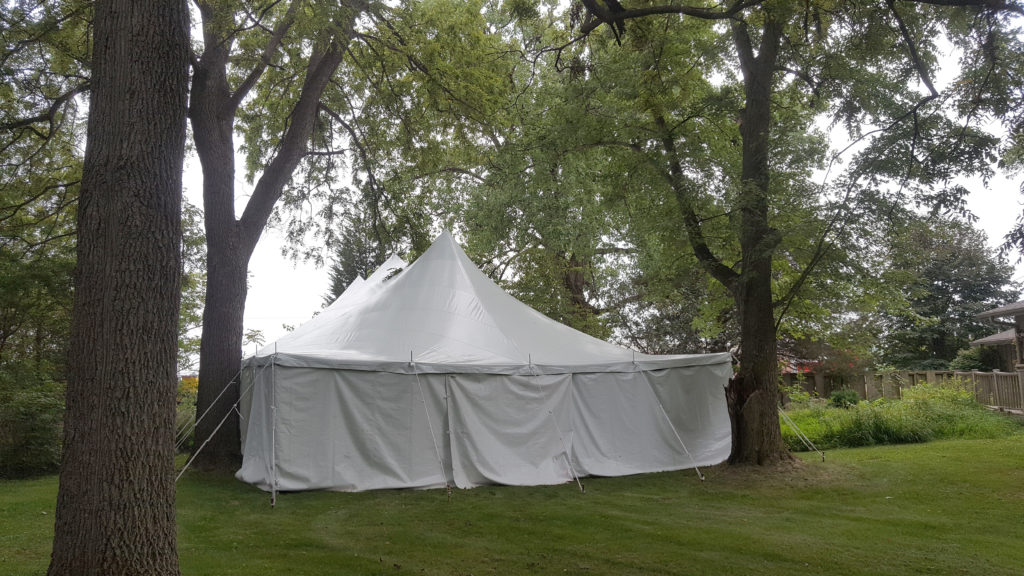 End of 30' x 60' rope and pole wedding tent with white sides Monticello, IA surrounded by trees