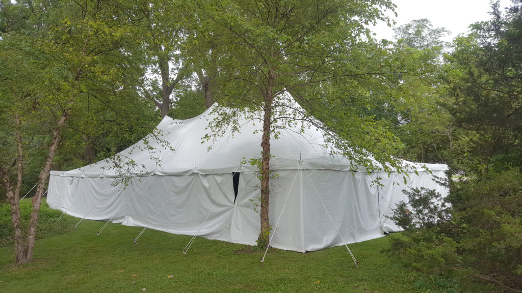 Side of 30' x 60' rope and pole wedding tent with white sides Monticello, IA surrounded by trees