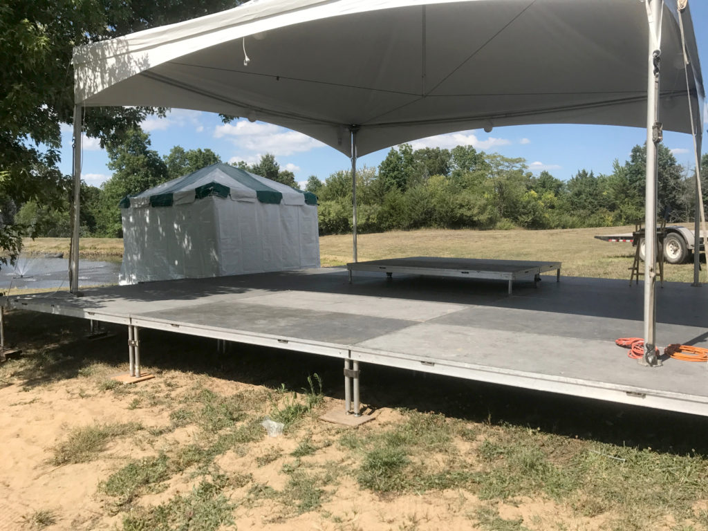 Stage with tent set up on top of it for Outdoor corporate event setup for West Liberty foods in Libertyville, Iowa