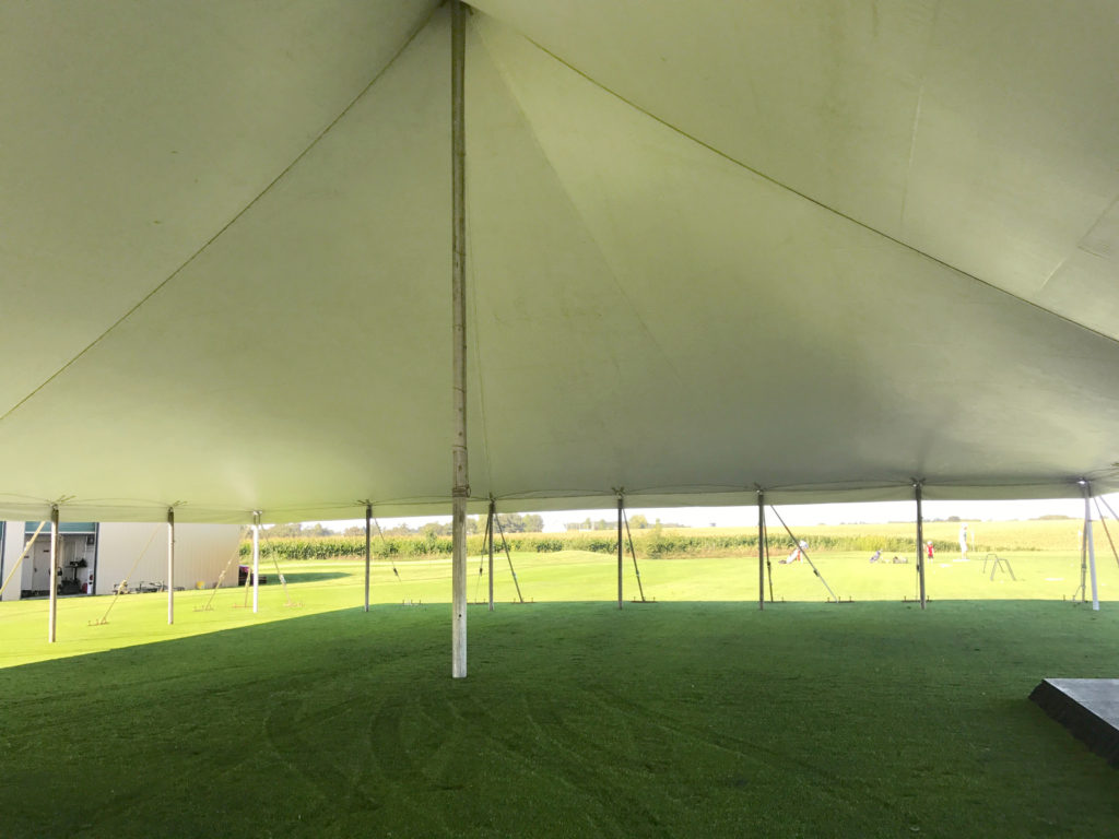 Under the white 60' x 90' rope and pole tent for a wedding reception in Newton, Iowa