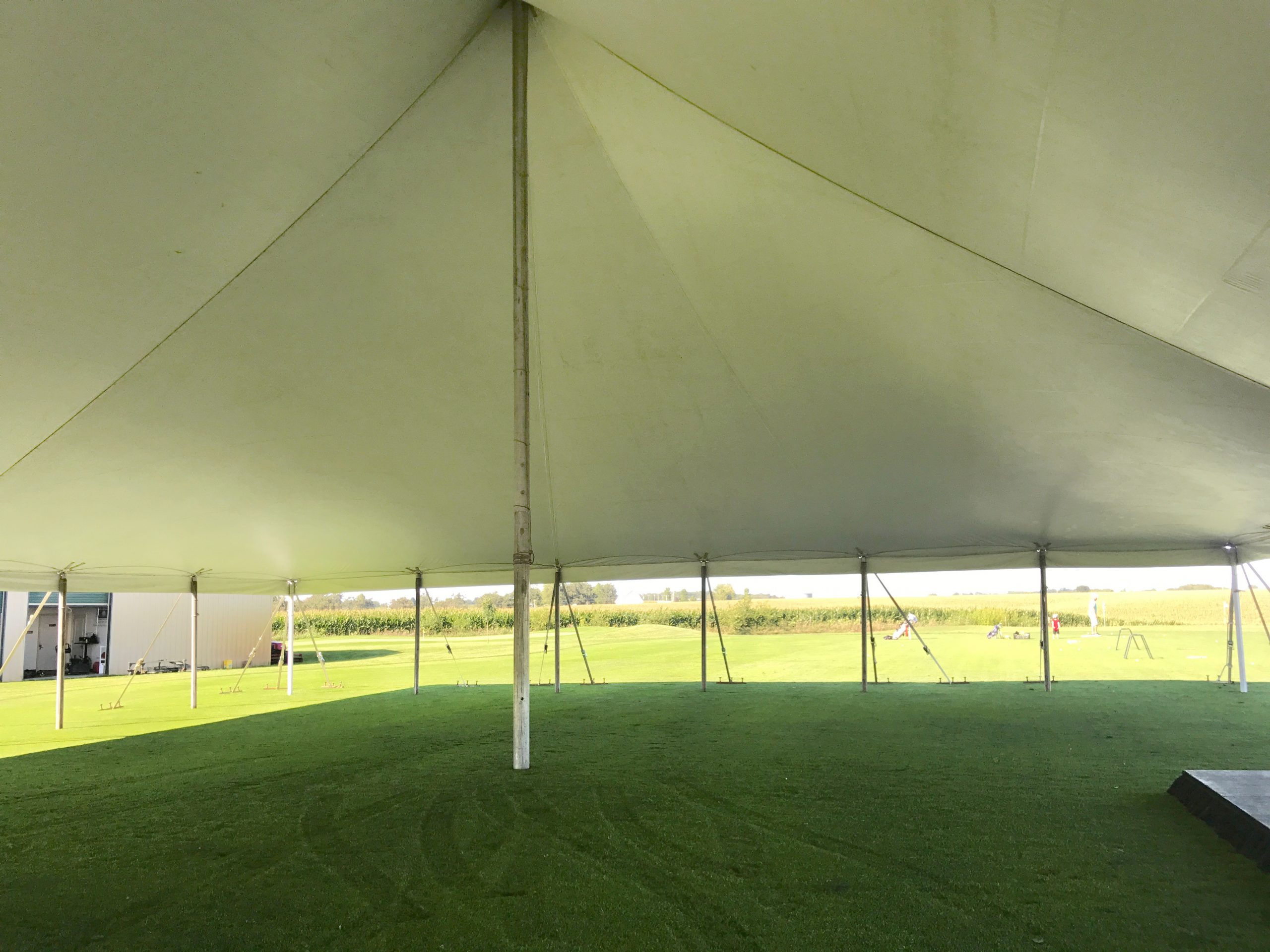 Under the white 60' x 90' rope and pole tent for a wedding reception in Newton, Iowa