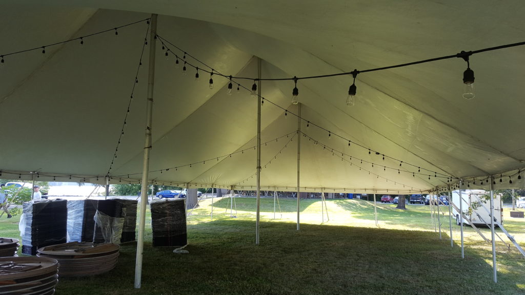 Under a 40' x 80' rope and pole tent with lights at a campground near Muscatine, Iowa