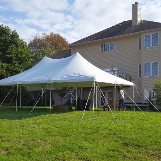 20' x 30' rope and pole tent with a home in the background