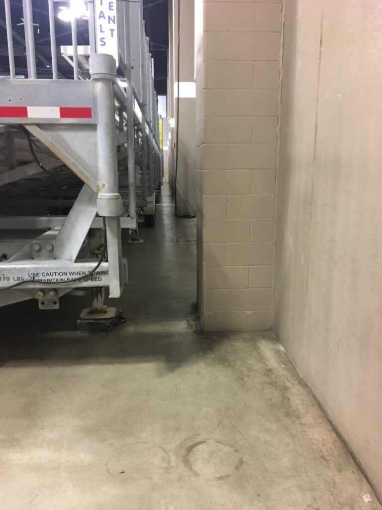 Space between towable bleachers and wall of the event center.