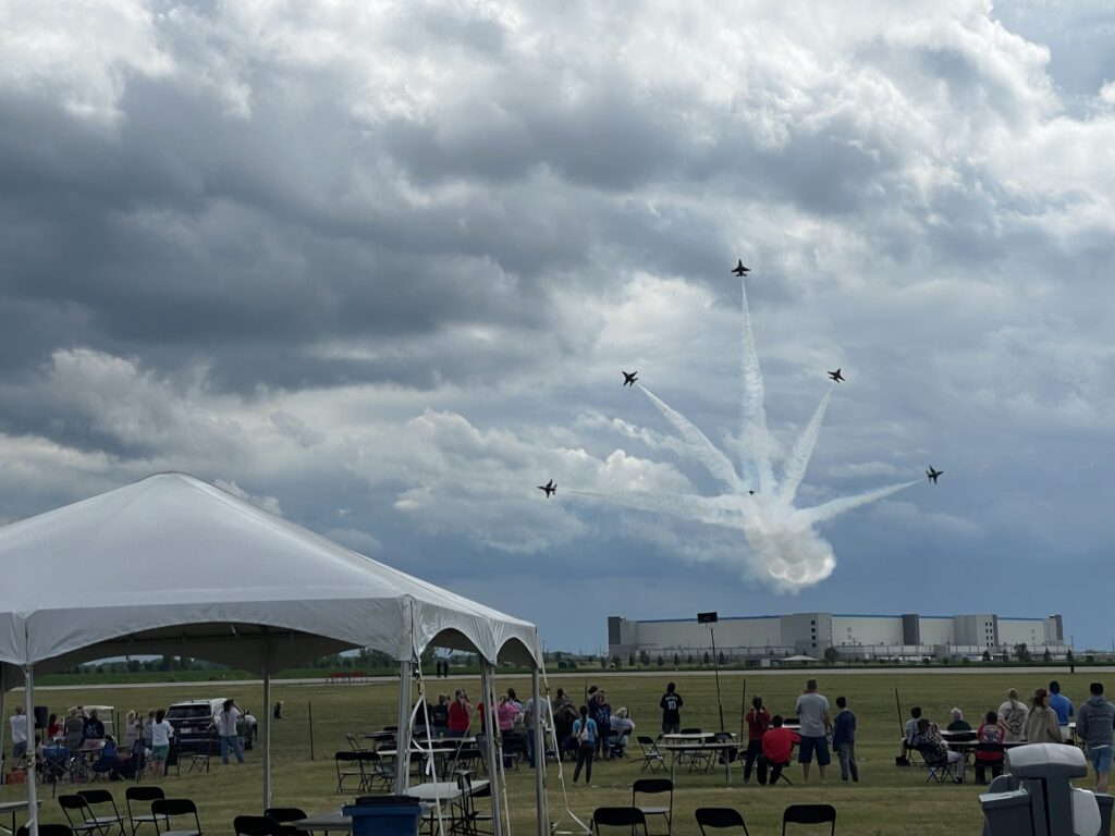 Frame tent with jets in the background at the Quad city air show set up by Big Ten Rentals