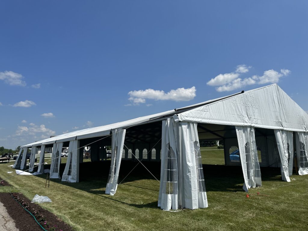 Finishing the last top of a 18m x 35m (60′ x 114′) Losberger clearspan temporary event tent structure for a wedding reception in Iowa City near Solon, IA