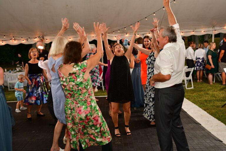 People on the dance floor at a wedding reception under a 60' x 90' legend twin-pole rope and pole tent.