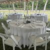 Round tables and chairs under a 60' x 90' legend twin-pole rope and pole tent.