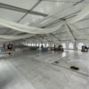 Under the 18m x 35m (60′ x 114′) Losberger clearspan temporary event structure with doors and subflooring set up for a wedding reception