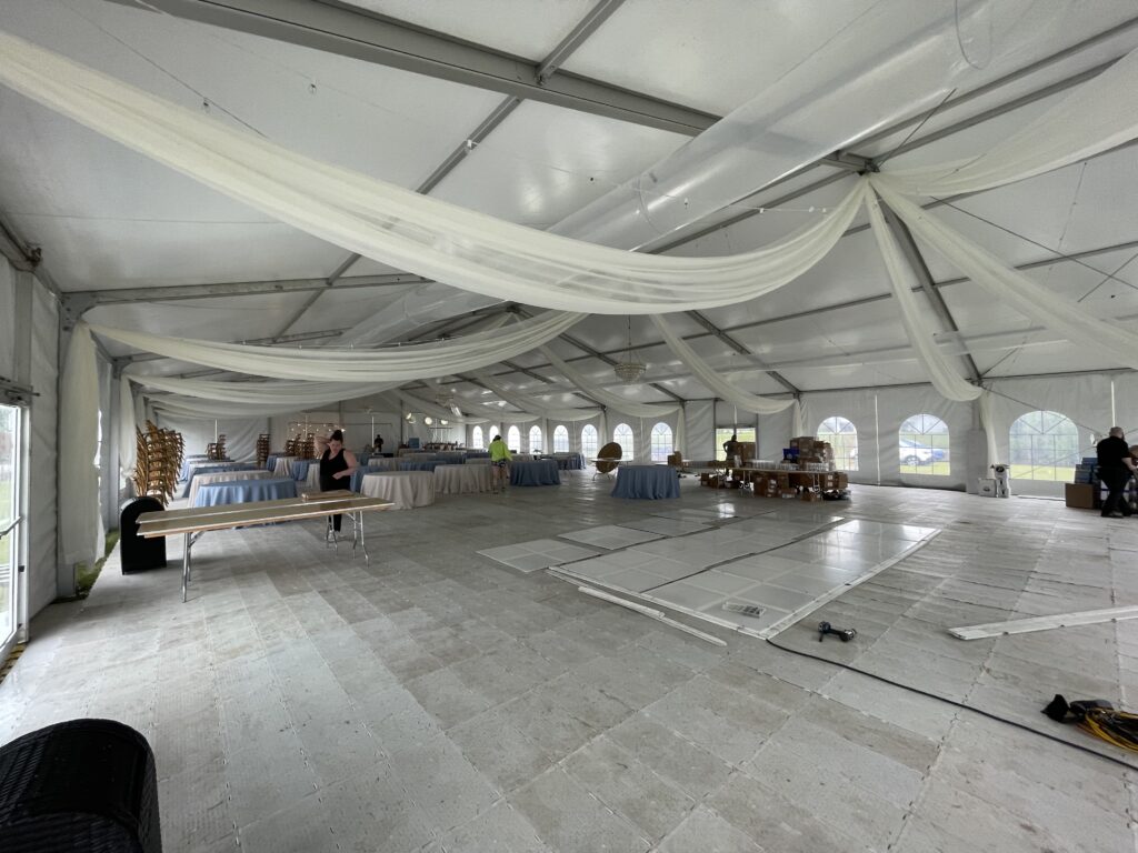 Under the 18m x 35m (60′ x 114′) Losberger clearspan temporary event structure with doors set up for a wedding reception