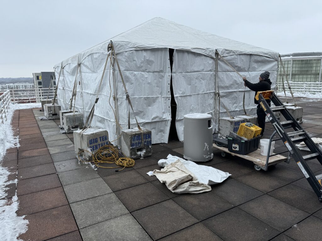 Crew working on setting up a 20' x 30' frame tent on the 3rd-floor terrace from the State Historical Building in Des Moines, Iowa.