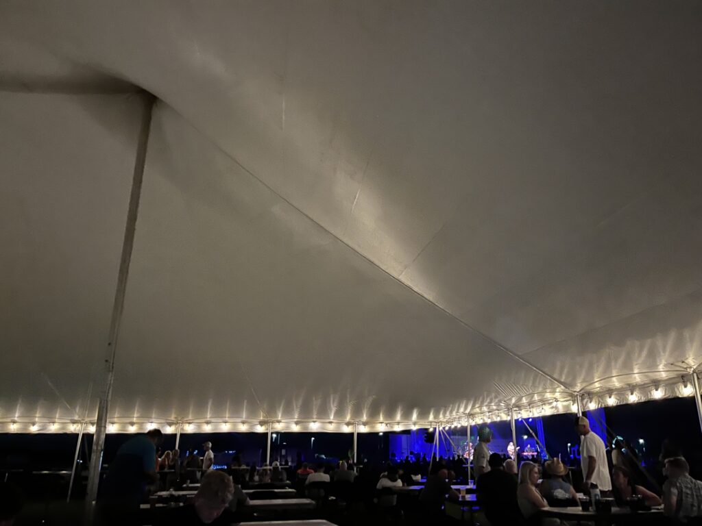 Under the a large event tent at North Liberty Blues & BBQ 2024