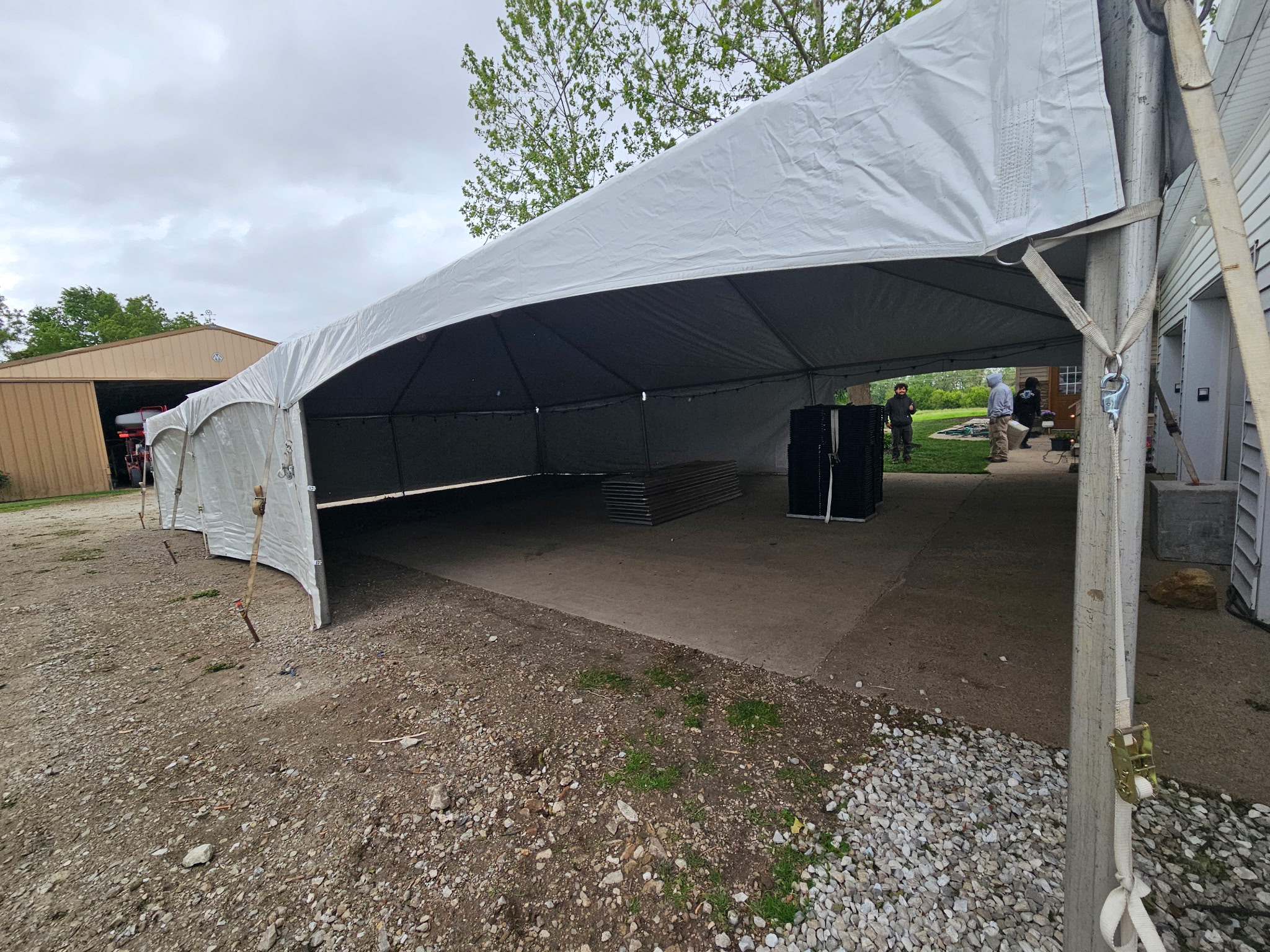 30' x 45' Frame Tent for a Graduation Party in Webster, Iowa with white sidewalls. Note the Block & Roll blocks over the concrete driveway.