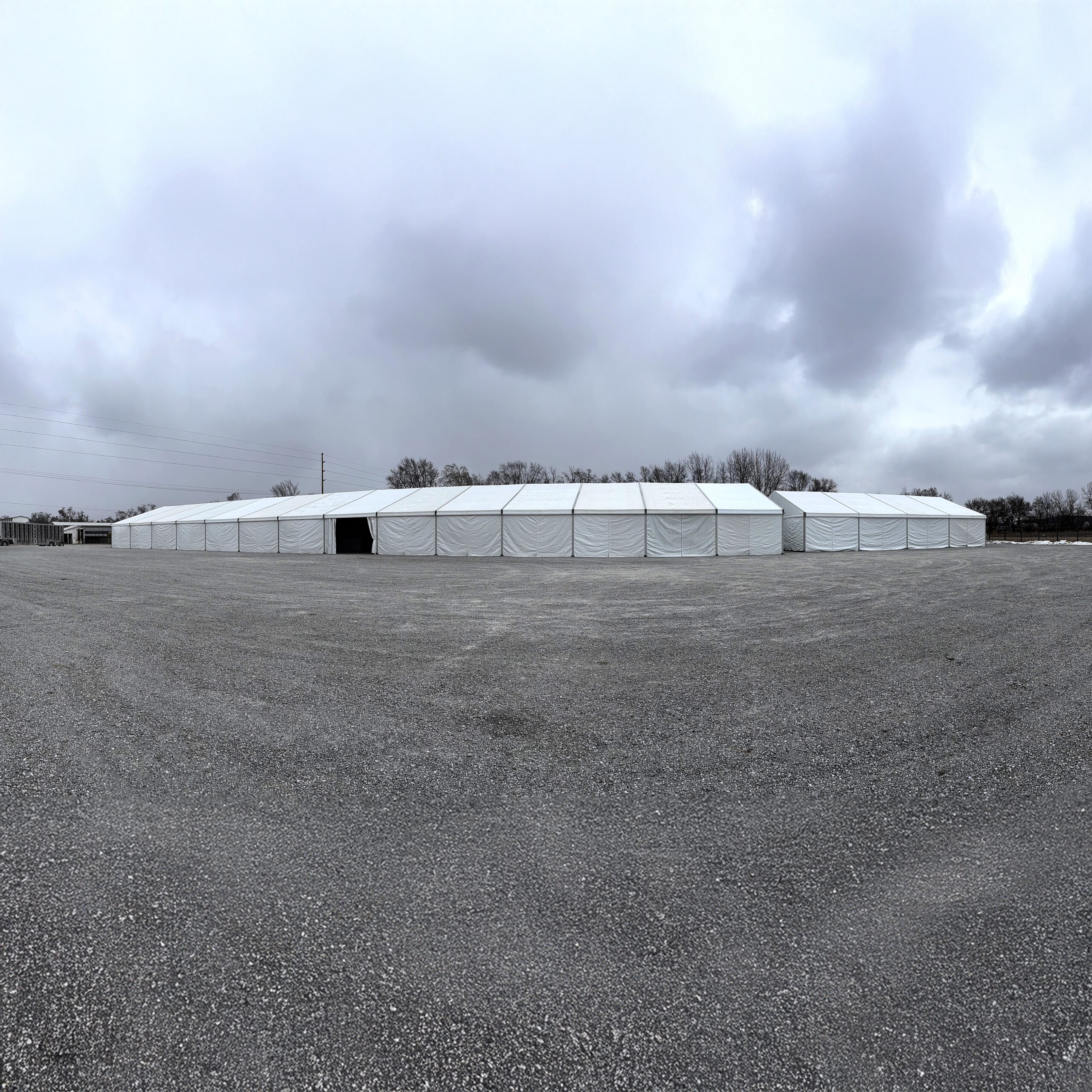 60' x 230' (18m x 70m) Losberger clearspan on the left and 49' x 66' (15m x 20m) Liri Clearspan tent on the right in Kalona, Iowa (panoramic)
