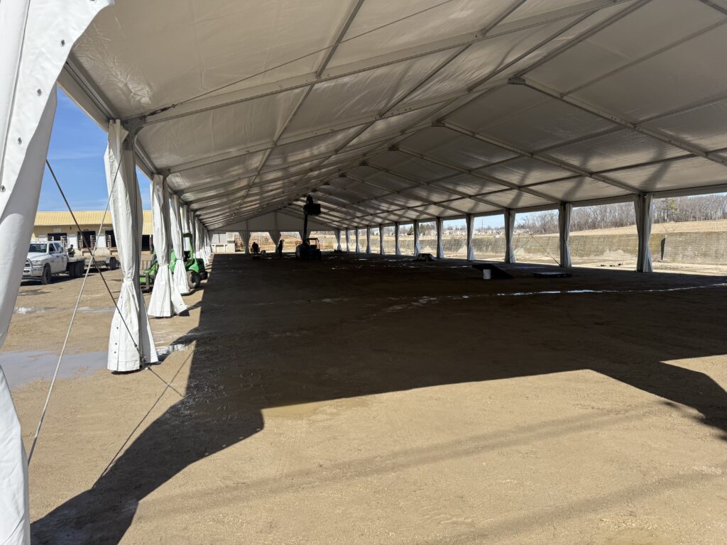 Crew adding lights using a Telehandlers (Telescopic Handlers) under a 60' x 230' (18m x 70m) Losberger Clearspan Tent at Waverly Midwest Horse Sale in Waverly, Iowa at Waverly Sales Co.