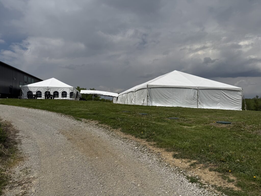 Full view of 30′ x 75′ Frame Tent on the left with 10′ x 30′ Frame Tent walkway into 40′ x 120′ Hybrid Tent on the right.