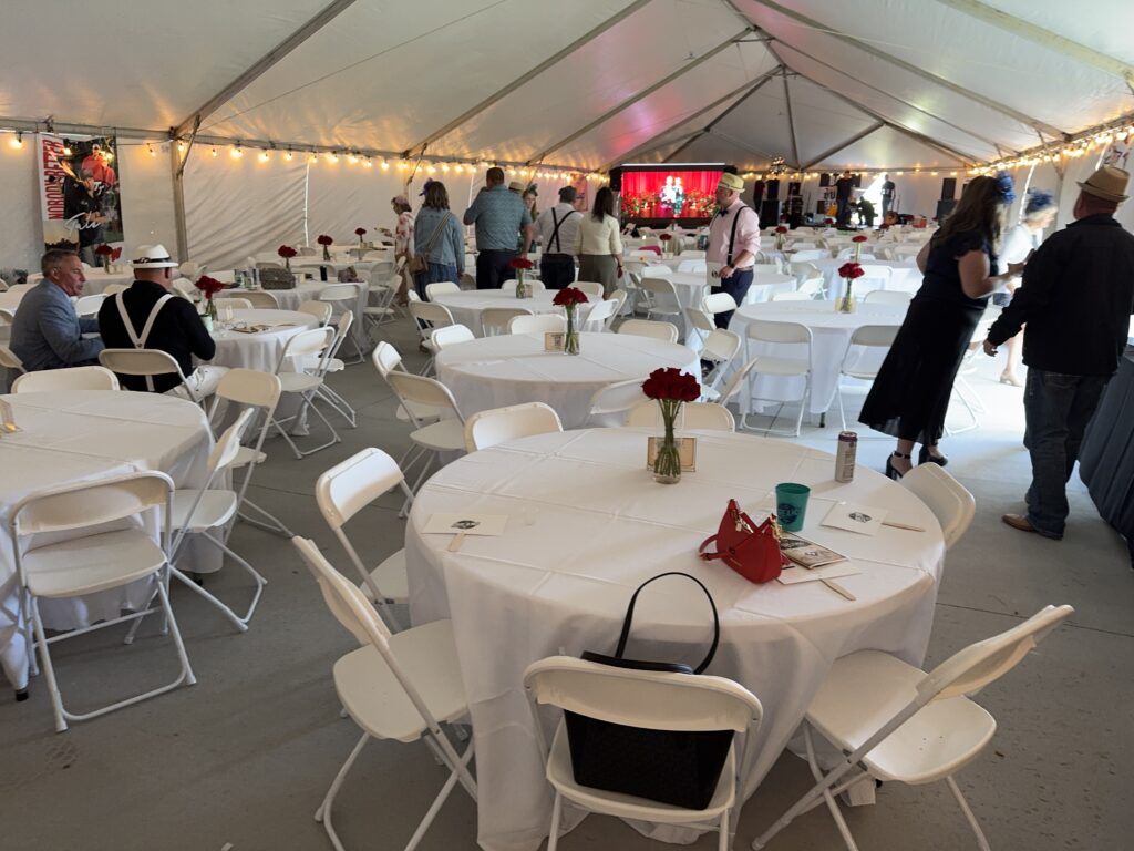 Round tables and folding white chairs under a 40′ x 120′ Jumbo Track event tent in Iowa.