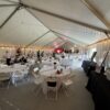 Round tables and folding white chairs under a 40′ x 120′ Jumbo Track event tent in Iowa.