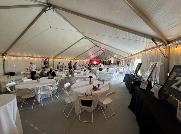 Round tables and folding white chairs under a 40′ x 120′ Jumbo Track event tent in Iowa. Round tables and folding white chairs under a 40′ x 120′ Jumbo Track event tent in Iowa.