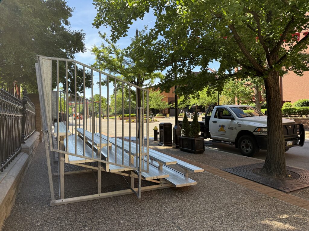 Side of a 5-Row Bleachers with railing outside of the Budweiser building for the 150th Anniversary Celebration in St. Louis, Missouri with a company truck