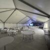 Under the 40′ x 120′ Hybrid Jumbotrac Event Tent with tables and chairs in the corner.