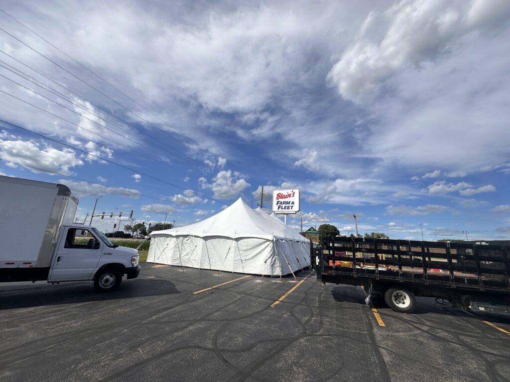 30' x 60' Rope and Pole Tent in Sterling, Illinois for Cornellier Fireworks with Blair's Farm & Fleet sign with Big Ten Rentals trucks