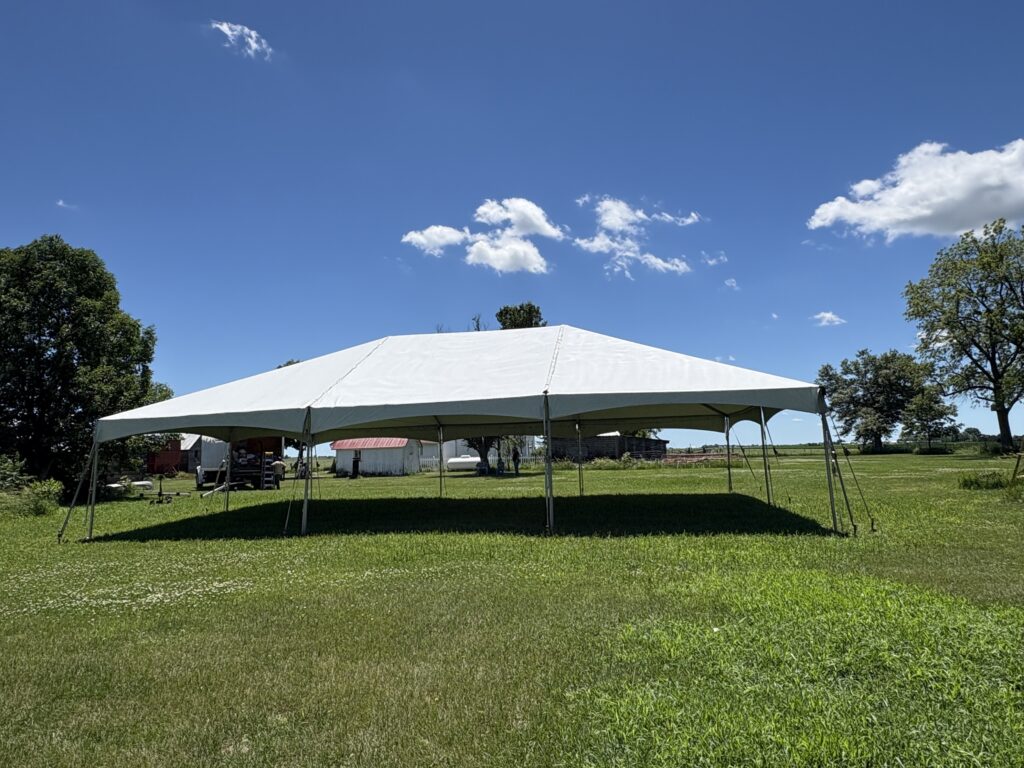 Side view of our 30' x 45' white frame tent installed on a grassy field in Keota, Iowa.