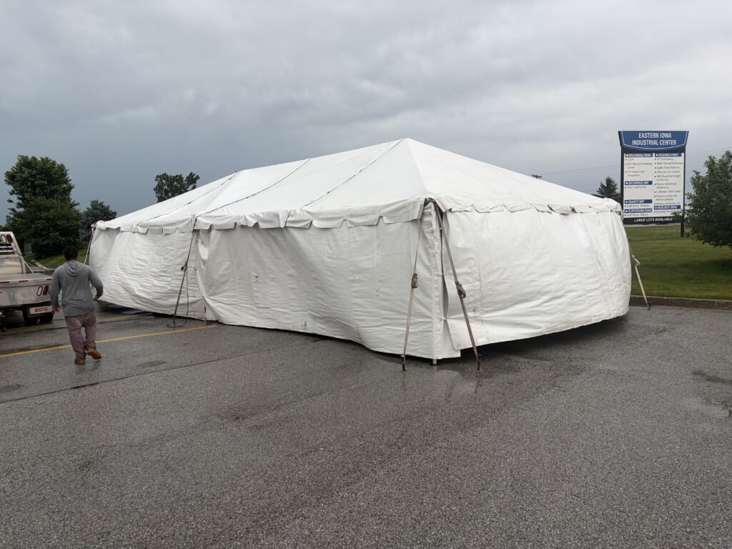 Team Big Ten Rentals on site in Davenport completing a 20' x 40' frame tent with sidewalls for TNT Fireworks. Built tough for Iowa weather — sidewalls keep everything dry and can be adjusted on the fly.