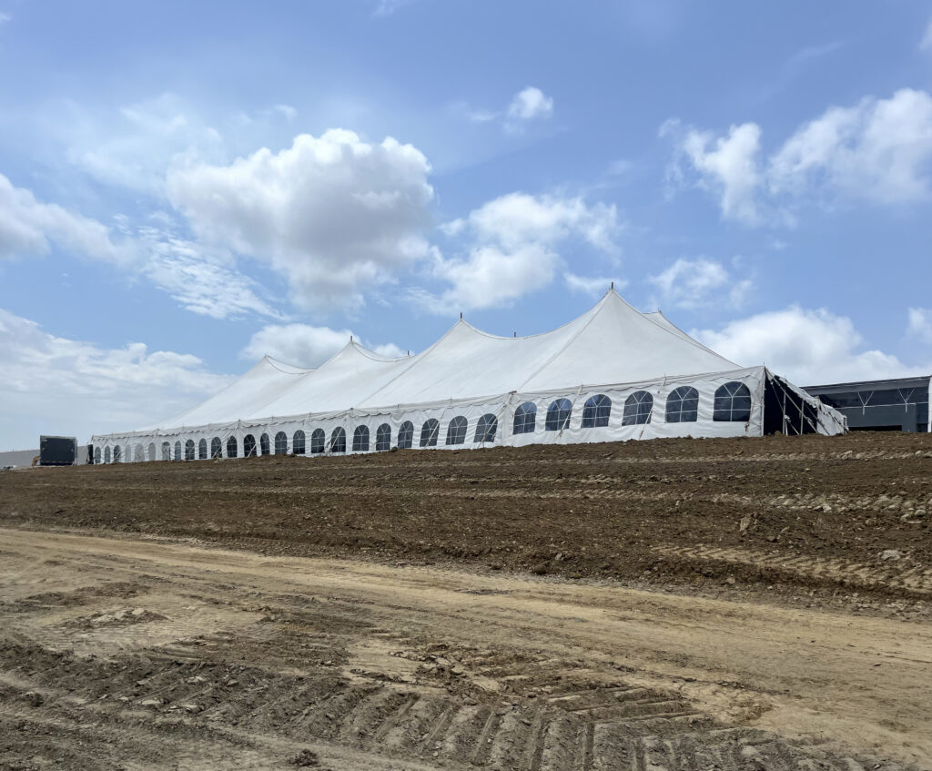 80' x 150' rope and pole event tent at a construction site in Iowa