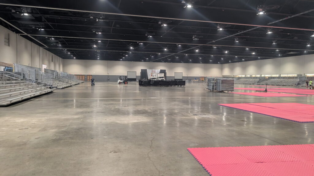 Expansive view of the prepared Schaumburg Convention Center hall with bleachers on both sides and open competition space for the WTSDA World Championships.