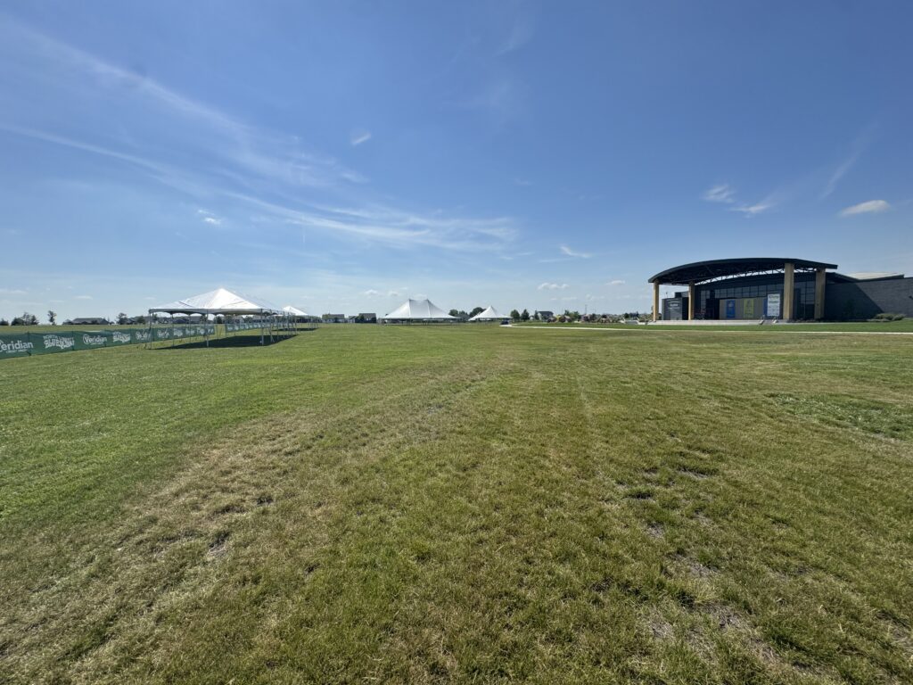 Multiple Event Tents set up for North Liberty Blues & BBQ at Centennial Park with the Hy-Vee Center amphitheater on the right