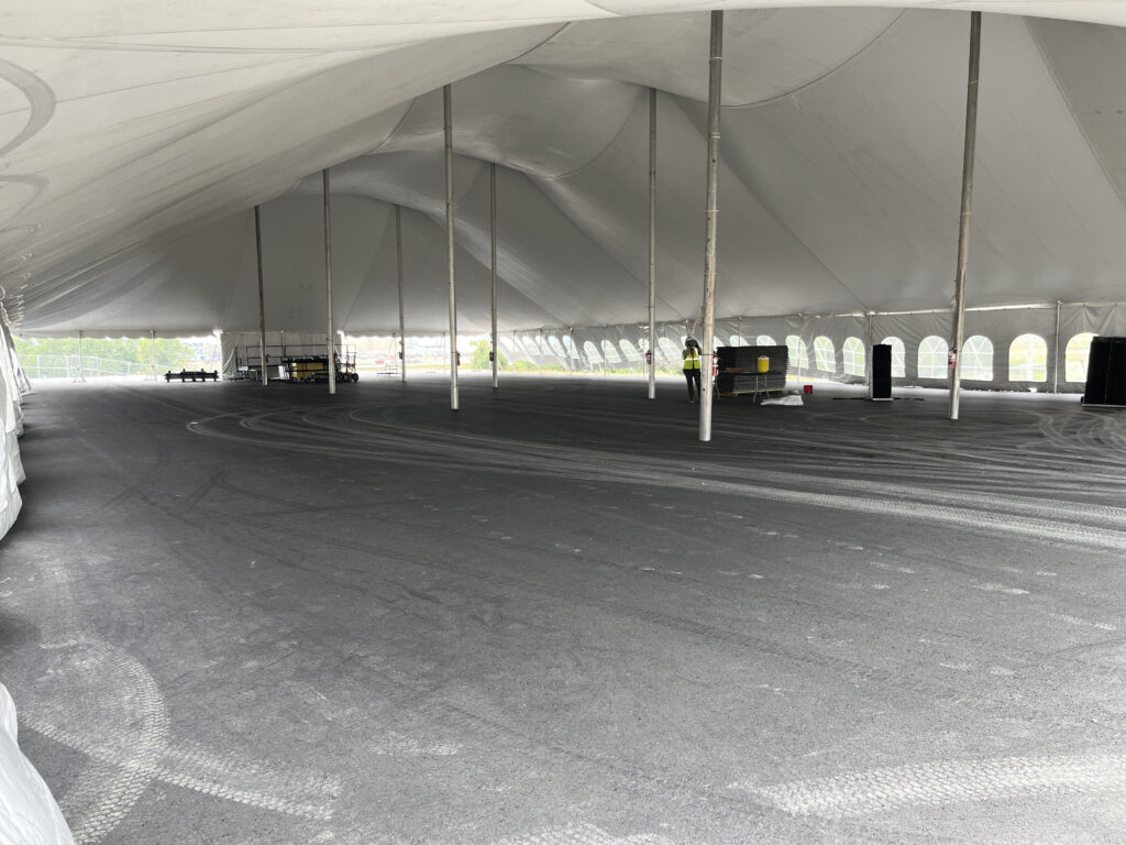 Under a "twin pole" 80' x 150' rope and pole event tent at a construction site in Iowa