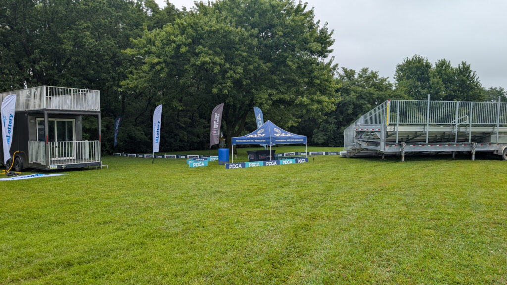 Hole 18: 45-foot, 10-row towable bleacher by the disc golf basket (or target) at the 2026 DGPT Discmania Challenge at Pickard Park in Indianola, Iowa