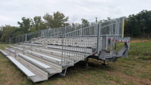 Hitch, I-beam frame, and unfolded seating on a 10-row, 45-foot highway-towable bleacher.