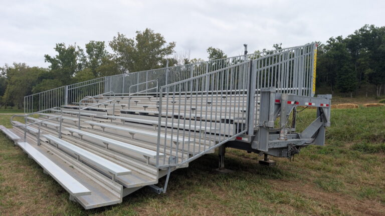 Hitch, I-beam frame, and unfolded seating on a 10-row, 45-foot highway-towable bleacher.